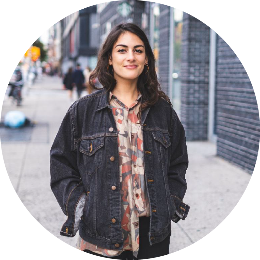 a photo of a woman standing outside on a sidewalk and smiling