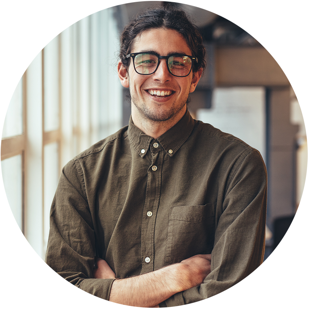 a photo of a man with glasses smiling and crossing his arms while looking forward