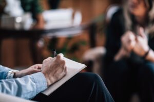 a person takes notes while asking another "is solution-focused therapy right for me?"