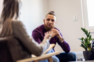 a group member listens to a therapist during gender-specific treatment