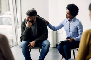 a therapist comforts someone in bipolar disorder treatment group therapy
