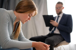 a person in a psychotherapy looks sad while they talk to a therapist