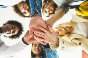 a ptsd therapy group puts their hands in a circle